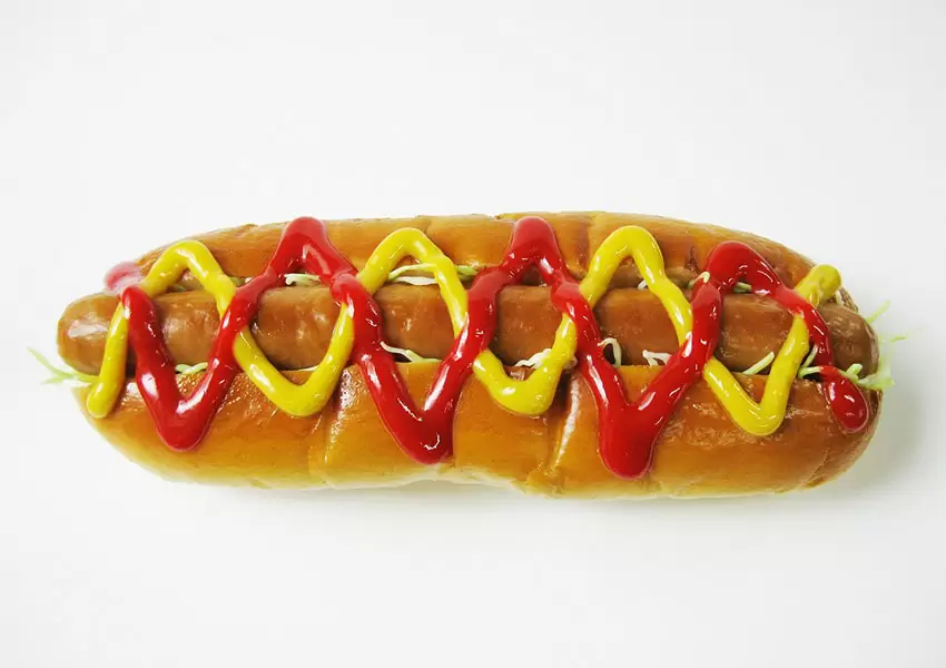 Perro caliente con salsa de tomate y mostaza